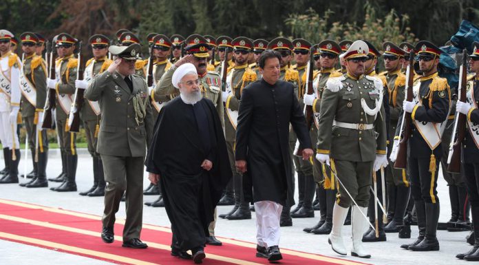 Iranian President Hassan Rouhani walks with Pakistani Prime Minister Imran Khan during a welcome ceremony in Tehran, Iran, April 22, 2019. (Reuters)